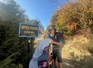 Trekker at Upper Pisang 3300m sign