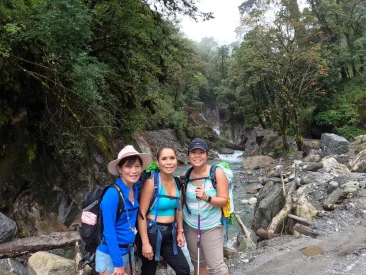 trekkers standing beside a rocky mountain riverbed